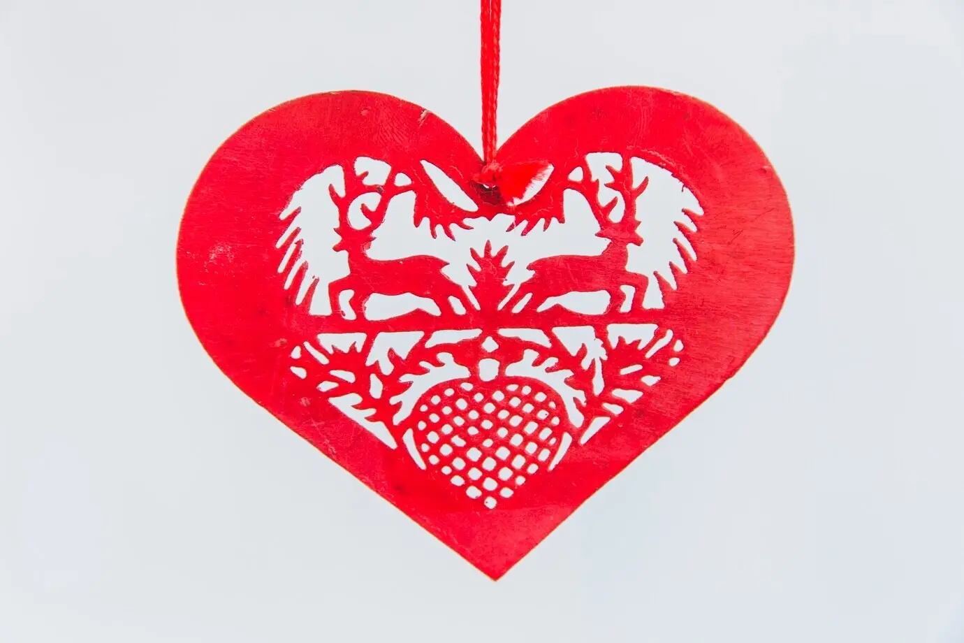 Roter, herzförmiger Weihnachtsschmuck auf weißem Hintergrund.