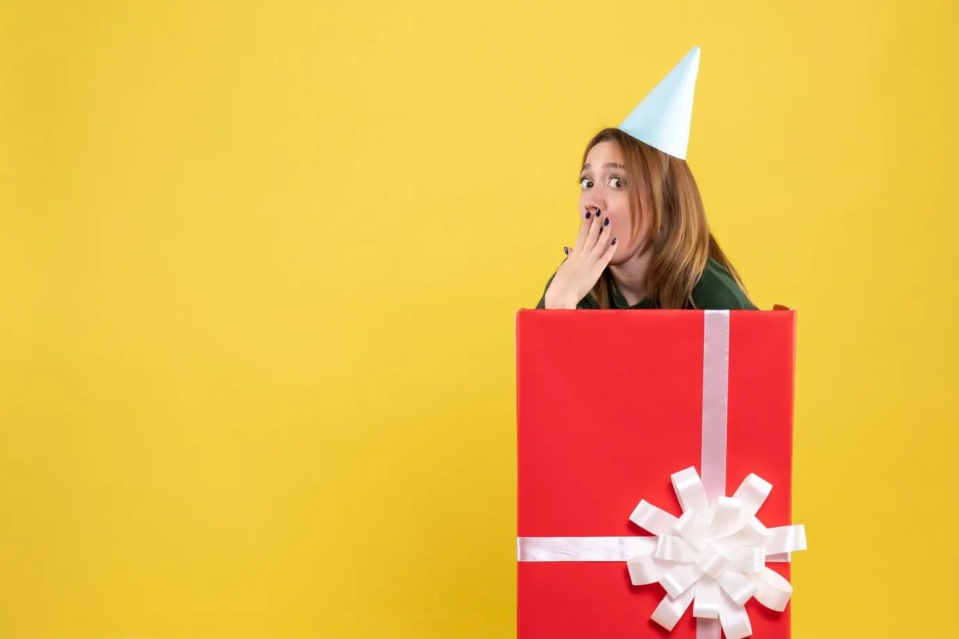 Überraschte junge weibliche Person in einem Geschenk, Frontalansicht.